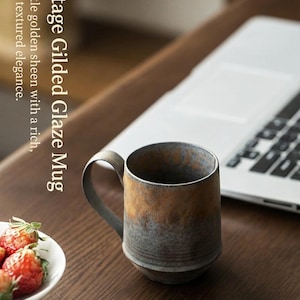 May include: A set of three ceramic mugs with a speckled, matte finish. The mugs are in shades of cream, light gray, and dark gray. Each mug has a simple, minimalist design, perfect for coffee or tea.