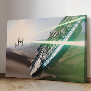 May include: Canvas art print featuring a spaceship firing green lasers at a smaller spacecraft in a desert landscape. The large ship is gray and white with detailed panels. The smaller ship is black. The background is a sandy desert with a light blue sky.