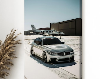 May include: A canvas print featuring a silver BMW sedan parked on a snowy surface, with a small airplane in the background. The sky is clear and blue. The car has black rims and a black front bumper.