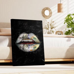 Puede incluir: Impresi&oacute;n en lienzo negro que presenta un primer plano de unos labios, cuyo dise&ntilde;o est&aacute; hecho con billetes de cien d&oacute;lares estadounidenses. Los labios abiertos revelan dientes blancos y un interior rojo, sobre un fondo negro texturizado.