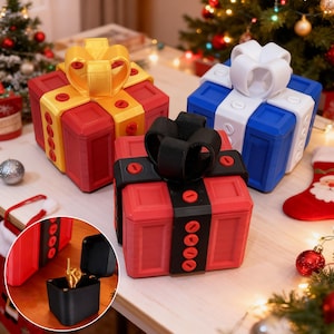 Pode incluir: Três caixas coloridas em forma de presente com laços. As caixas são vermelhas, azuis e vermelhas, com laços amarelos, brancos e pretos, respectivamente. Cada caixa tem uma forma quadrada e é decorada com detalhes circulares. As caixas estão numa mesa com decorações de Natal.