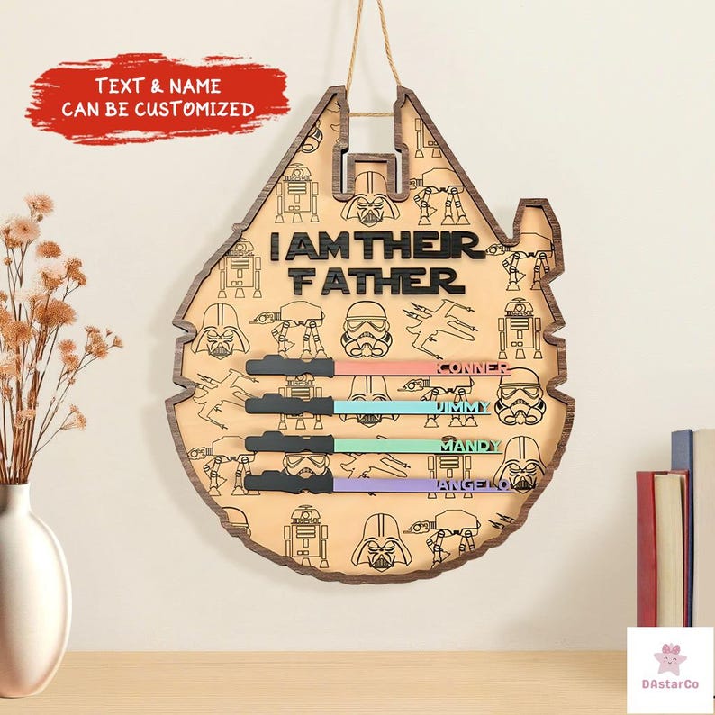 a wooden sign with a Star Wars theme, hanging on a wall. The sign has a Star Wars logo and the text "I AM THEIR FATHER" written on it. There are also various Star Wars characters and elements, such as the Millennium Falcon, Star Wars Death Star, and the Millennium Falcon's tail, which are visible on the sign.
