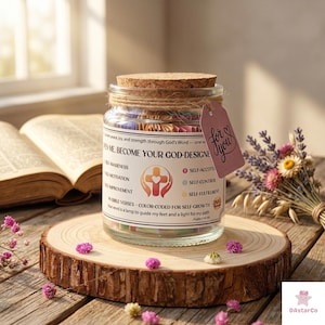 May include: A glass jar with a cork lid, filled with colourful paper strips, sits on a wooden slice. The jar has a label with text and a cross symbol. A small tag reads "for you". A book and flowers are nearby.