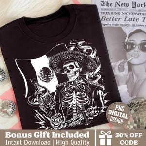 以下が含まれることがあります： 黒いTシャツ。ソンブレロをかぶった骸骨がボトルを持ち、メキシコ国旗の前に立っている白黒グラフィック。デザインにはバラと「PNG DIGITAL DESIGN」の文字が含まれています。
