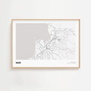 May include: A framed print of a map of Nadi, Fiji, in black and white. The map shows the city's road network and surrounding coastline. The word "NADI" is printed in a bold, sans-serif font at the bottom left.