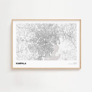 Könnte beinhalten: Ein gerahmter Kartendruck von Kampala, Uganda, in Schwarzweiß. Das Straßennetz der Stadt ist detailliert, mit dem Stadtnamen unten links. Der Rahmen hat eine helle Holzfarbe.