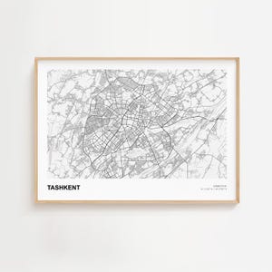 May include: A framed black and white map print of Tashkent, Uzbekistan. The city map is detailed with roads and buildings. The print includes the city name and coordinates.