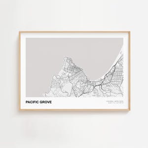 May include: A framed map print of Pacific Grove, California, in black and white. The map shows the city's streets and coastline against a light gray background. The text "PACIFIC GROVE" is at the bottom, with coordinates and "CALIFORNIA, UNITED STATES" below.