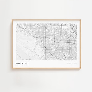 May include: A framed black and white map of Cupertino, California, USA. The map shows the city's road network and geographical features. The text "Cupertino" is at the bottom left, with coordinates at the bottom right.