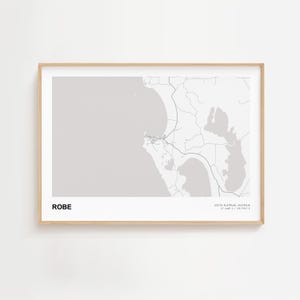Pode incluir: Impressão emoldurada de um mapa a preto e branco de Robe, Austrália do Sul. O mapa mostra a região costeira com estradas e características geográficas. A palavra "ROBE" é impressa na parte inferior esquerda. Coordenadas na parte inferior direita.