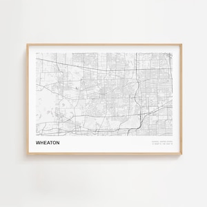 May include: A framed map print of Wheaton, Illinois, in black and white. The map details the city's streets and infrastructure. The word "WHEATON" is printed in bold, black letters at the bottom left.