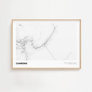 May include: A framed monochrome map print of Chamonix, France. The print shows a detailed topographical representation of the area, with the name "CHAMONIX" at the bottom left and coordinates at the bottom right.