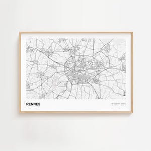 May include: A framed black and white map print of Rennes, France. The city map features a detailed network of roads and streets. The word "RENNES" is printed in bold, black letters at the bottom left. Coordinates are printed at the bottom right.