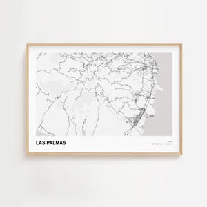 Puede incluir: Una impresión enmarcada en blanco y negro del mapa de Las Palmas, España. El mapa presenta calles y topografía detalladas de la ciudad, con el nombre de la ciudad en la parte inferior. La impresión está en un marco de madera clara.