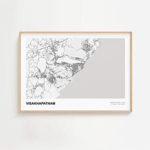May include: A framed print of a map of Visakhapatnam, India, in grayscale. The city name is printed in a bold font at the bottom left. The map shows roads, buildings, and the coastline. The frame is a light wood colour.
