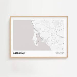 Könnte beinhalten: Ein gerahmter Graustufen-Kartendruck von Bodega Bay, Kalifornien. Die Karte zeigt die Küstenlinie, Straßen und geografischen Merkmale. Der Text "Bodega Bay" befindet sich unten links, mit Koordinaten und "California, United States" unten rechts.