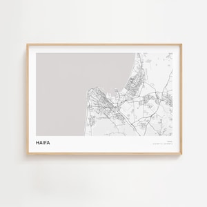 Puede incluir: Una impresión enmarcada del mapa de Haifa, Israel, en blanco y negro. El diseño de la ciudad es detallado, con carreteras y edificios visibles. La palabra "HAIFA" está impresa en negrita, en una fuente sans-serif en la parte inferior izquierda.