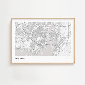 May include: A framed map print of Montreal, Canada, in grayscale. The city map features detailed street layouts, waterways, and parks. The word "MONTREAL" is printed in a bold, sans-serif font at the bottom left. The frame is a light wood color.