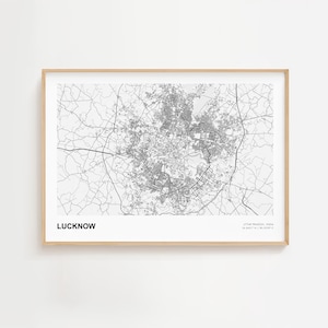 May include: A framed black and white map of Lucknow, India. The city map is detailed with roads and buildings, set against a white background. The word "LUCKNOW" is printed in bold, with coordinates below.