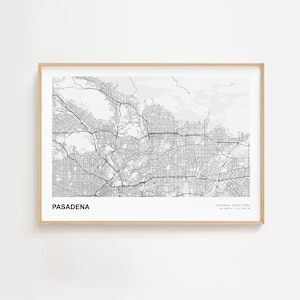 May include: A framed black and white map of Pasadena, California, with the city's name at the bottom left. The map shows streets and topography. The frame is a light wood color.