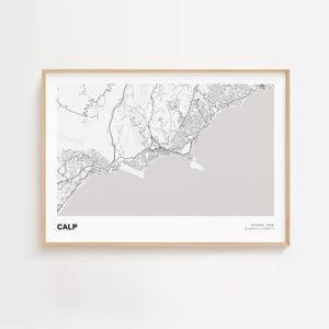 May include: A framed print featuring a grayscale map of Calp, Spain. The map details the coastal region with roads and geographical features. The word "CALP" is printed in the lower left corner, with location coordinates in the lower right.