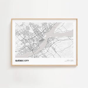 May include: A framed grayscale map print of Quebec City, Canada. The map shows the city's layout, including roads, buildings, and the St. Lawrence River. The text "QUÉBEC CITY" is at the bottom left.