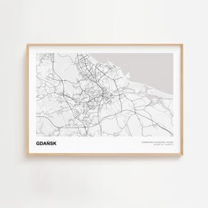 Könnte beinhalten: Eine gerahmte Graustufenkarte von Gdańsk, Polen, mit dem Straßennetz und der Küstenlinie der Stadt. Der Name der Stadt ist unten links in fetten, schwarzen Buchstaben aufgedruckt. Der Rahmen hat eine helle Holzfarbe.