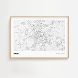 Peut inclure: Une impression encadrée en noir et blanc de la carte de Bâle, Suisse. La carte de la ville présente des plans de rues détaillés et des caractéristiques géographiques. L'impression est dans un cadre en bois clair, idéale pour la décoration.