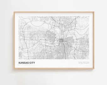 May include: A framed black and white map of Kansas City, Missouri, with the city name printed in bold black letters at the bottom left. The map shows the city's road network and waterways.