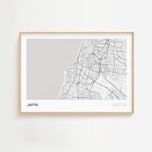 Puede incluir: Una impresión enmarcada del mapa de Jaffa, Israel, en blanco y negro. El mapa muestra las calles y la costa de la ciudad sobre un fondo gris claro. La palabra "JAFFA" está impresa en negrita en la parte inferior izquierda.