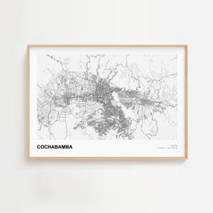 Pode incluir: Impressão emoldurada em preto e branco do mapa de Cochabamba, Bolívia. O mapa da cidade é detalhado, mostrando ruas e áreas circundantes. A impressão está em uma moldura de madeira clara e é exibida contra uma parede branca.