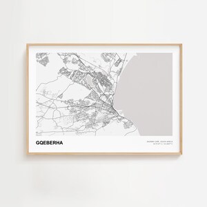 Peut inclure: Une impression encadrée d'une carte de Gqeberha, Cap-Oriental, Afrique du Sud, en noir et blanc. La carte montre la disposition de la ville avec les routes et les bâtiments, et une zone gris clair représentant la côte. Le nom de la ville est imprimé en gras.