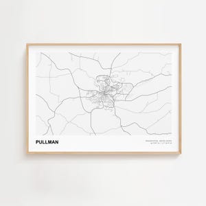 Pode incluir: Uma impressão emoldurada em preto e branco de um mapa de Pullman, Washington, EUA. O mapa mostra a rede rodoviária da cidade e está rotulado "Pullman" no canto inferior esquerdo. A moldura é de cor de madeira clara.