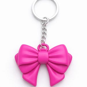May include: A bright pink bow-shaped keychain. The bow is a solid, glossy color and has a detailed, three-dimensional design. The keychain includes a silver-colored chain and a ring for attaching keys.