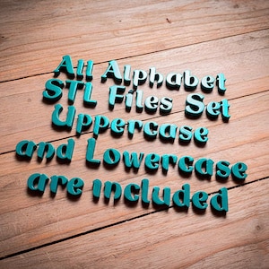 Puede incluir: Letras de alfabeto turquesas impresas en 3D que deletrean "All Alphabet STL Files Set Uppercase and Lowercase are included" sobre una superficie de madera. Las letras están en una fuente en negrita y redondeada.