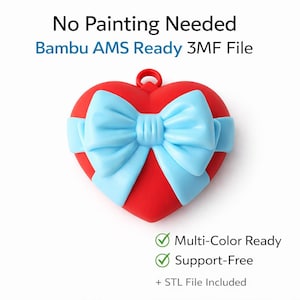 May include: A red heart-shaped ornament with a light blue bow wrapped around it. The ornament has a loop at the top for hanging. Text on the image reads "No Painting Needed" and "Bambu AMS Ready 3MF File".