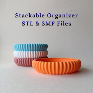 Può includere: Ciotole organizer impilabili in vari colori: blu, bianco, rosa e arancione. Le ciotole hanno un design a coste e sono impilate. Il testo sull'immagine recita "Stackable Organizer STL & 3MF Files."