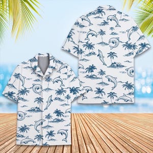 Könnte beinhalten: Weißes kurzärmeliges Hemd mit blauem Delfin- und Palmenmuster. Das Hemd hat einen klassischen Kragen und eine lockere Passform. Das Design zeigt Delfine in verschiedenen Posen und tropische Landschaften.