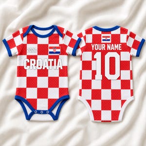 K&ouml;nnte beinhalten: Zwei Babybodys mit rot-wei&szlig;em Karomuster. Die Vorderseite zeigt den Text 2026, das Wort CROATIA und eine kleine kroatische Flagge. Die R&uuml;ckseite zeigt den Text YOUR NAME und die Nummer 10 mit einer kleinen kroatischen Flagge dar&uuml;ber.