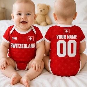 Puede incluir: Un body de bebé rojo con ribetes blancos que presenta el texto SWITZERLAND, 2026 y una bandera suiza en la parte delantera, y el texto YOUR NAME y 00 en la parte trasera. La tela tiene un sutil patrón repetitivo de cruces suizas.