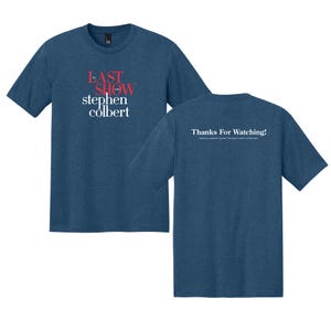 May include: Two blue t-shirts. The front shirt has the text "LAST SHOW stephen colbert" in red and white. The back shirt has the text "Thanks For Watching!" in white. The shirts are made of a soft material.