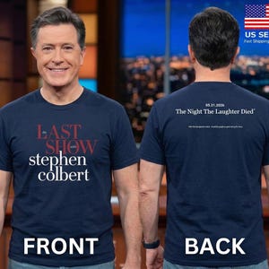 May include: Navy blue t-shirt with the text "The Last Show with Stephen Colbert" on the front. The back of the shirt reads "05.21.2026 The Night The Laughter Died". The shirt is a short-sleeved crew neck.