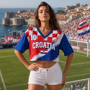 May include: A cropped V-neck t-shirt featuring a red and white chequered pattern, the number 10, the word CROATIA in white lettering, and a small Croatian flag emblem, paired with white denim shorts with a frayed hemline and a button closure.