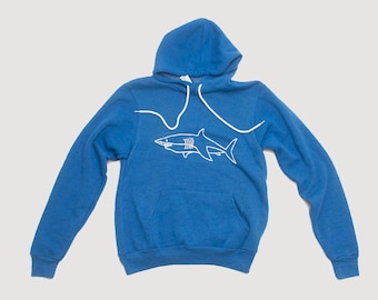 Op de afbeelding: Een blauw hoodie met een witte omtrek van een haai op de voorkant.