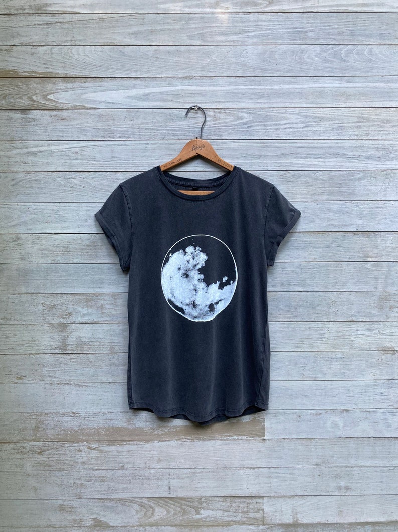 K&ouml;nnte beinhalten: Ein schwarzes T-Shirt mit einem wei&szlig;en Motiv eines Mondes mit Wolken.