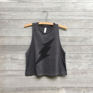 May include: A dark gray sleeveless shirt with a black lightning bolt graphic.