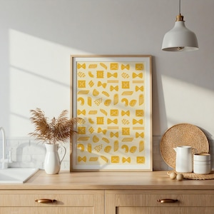 Puede incluir: Una impresión artística enmarcada con un patrón repetido de formas de pasta amarillas sobre un fondo crema. La impresión se exhibe en un mueble de madera en un entorno de cocina, con un jarrón blanco y objetos decorativos.