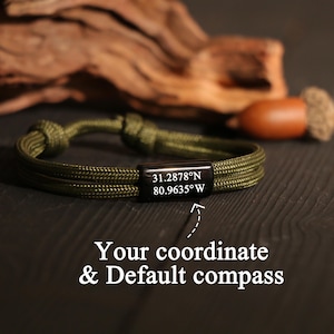 Puede incluir: Pulsera de cuerda verde oliva con una barra de metal negro grabada con coordenadas. La pulsera está anudada en ambos extremos. El texto en la parte inferior dice "Your coordinate & Default compass".