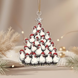 Peut inclure: Ornement transparent en forme de sapin de Noël, représentant un groupe de poulets blancs portant des bonnets de Père Noël rouges. L'ornement est surmonté d'une étoile et d'une ficelle dorée pour l'accrocher. Décoration de vacances festive et fantaisiste.