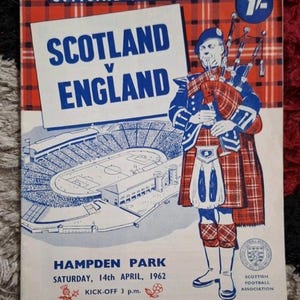 May include: A vintage official programme for the Scotland v England football match. The cover displays a stadium illustration and a bagpiper in Scottish dress. Text includes "Hampden Park" and the date, 14th April, 1962. The price is 1/4.